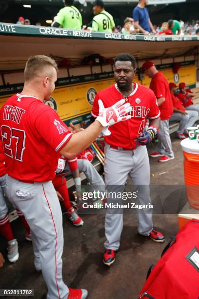 Mike Trout and Brandon Phillips of the Los Angeles Angels of Anaheim go through a pregame ritual in the dugout prior to the game against the Oakland...