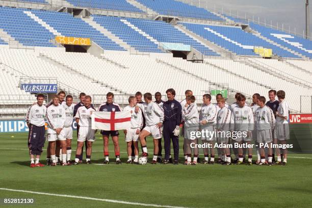 England coach Glenn Hoddle holds aloft the England flag as he poses with his team before the World Cup match against Tunisia at the Velodrome Stadium...