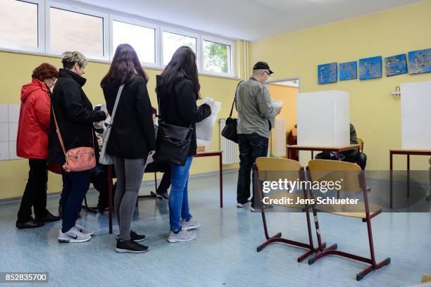 People are waiting for the vote at a polling station during German federal elections on September 24, 2017 in Halle, Germany. German Chancellor and...