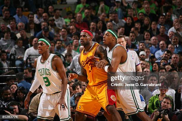 LeBron James of the Cleveland Cavaliers boxes out against Paul Pierce and Rajon Rondo of the Boston Celtics during the game on March 6, 2009 at the...