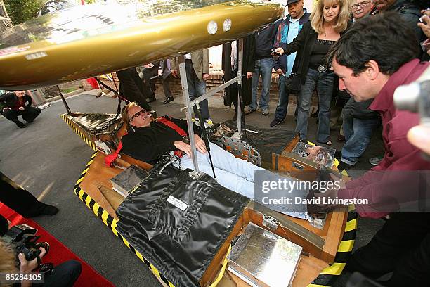 Actor Peter Fonda lays in the Solar XOF1 car assisted by the vehicle's designer Marcelo da Luz at its unveiling during a reception at the official...