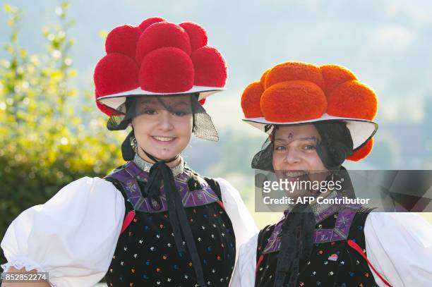 Christina Lehmann and Jana Bruestle pose in traditional dresses of the Black Forest region with the red Bollenhut in Gutach, southern Germany, on...