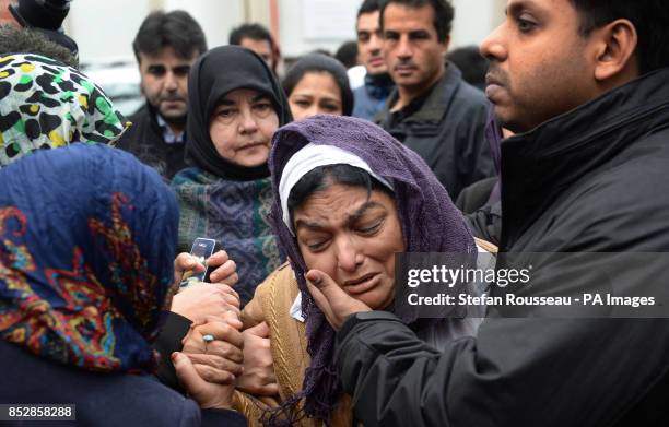 Fatima Khan, mother of Dr Abbas Khan 32, who died while being held in custody in Syria, is comforted by her son at a service for the British doctor...