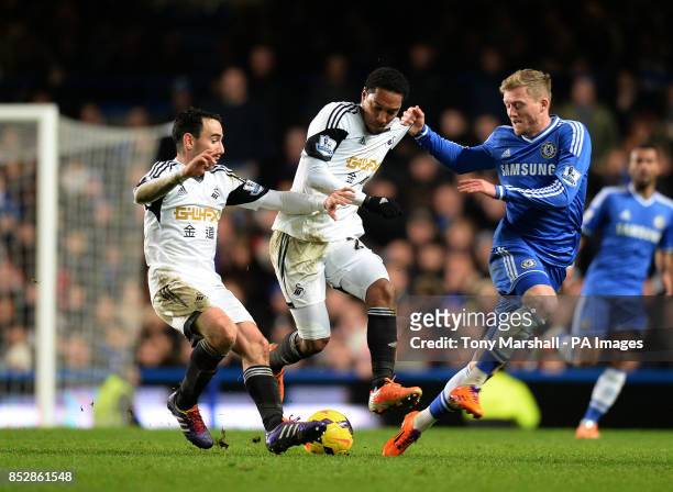 Chelsea's Andre Schurrle tackled by Swansea's Leon Britton and Jonathan de Guzman during the Barclays Premier League match at Stamford Bridge, London.