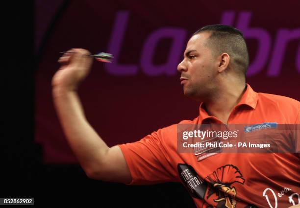 Devon Petersen celebratein action in the first Set against Justin Pipeduring day twelve of The Ladbrokes World Darts Championship at Alexandra...