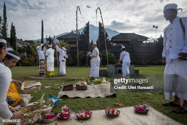 Balinese hindu worshipers prepare for prayer at Besakih temple who in danger zones as mount Agung is seen on the background on September 24, 2017 in...