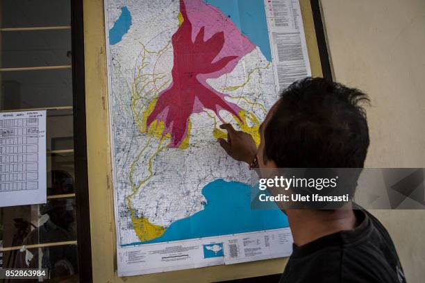 Man looks a map of the danger zones at the mount Agung monitoring station on September 24, 2017 in Karangasem regency, Island of Bali, Indonesia....