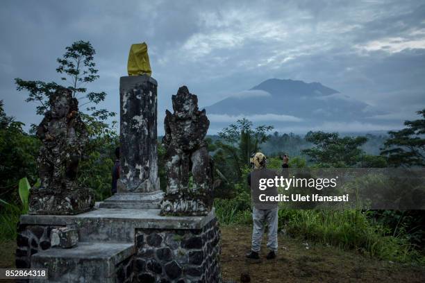 Man takes a picture of mount Agung on September 24, 2017 in Karangasem regency, Island of Bali, Indonesia. Indonesian authorities raised the alert...