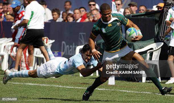 Argentina's Martin Bustos Moyano tries to stop South Africa's Ryno Benjamin during their quarter final match on the third day of the Dubai Rugby...