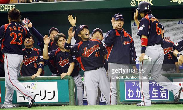 Outfielder Norichika Aoki and Infielder Hiroyuki Nakajima of Japan celebrate after scoring with team mates in the top half of the first inning the...