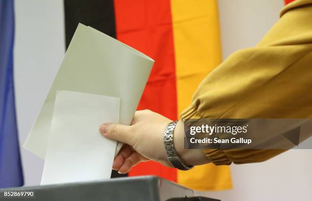 Voter casts her ballot at a polling station during German federal elections on September 24, 2017 in Berlin, Germany. German Chancellor and Christian...