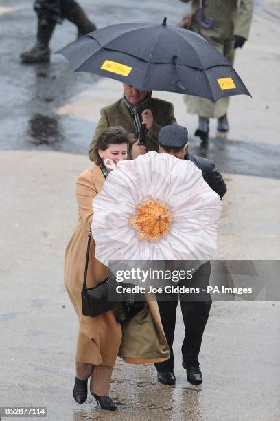 Racegoers battle the elements on New Year's Day at Cheltenham Racecourse.