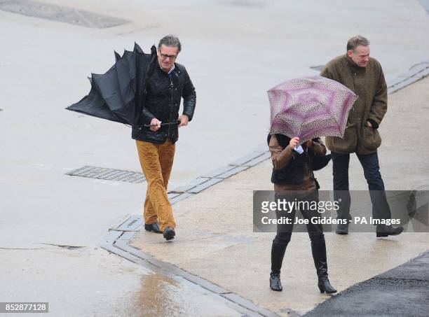 Racegoers battle the elements on New Year's Day at Cheltenham Racecourse.