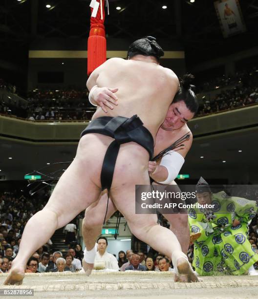 Mongolian yokozuna, or grand champion, Harumafuji pushes out ozeki-ranked wrestler Goeido of Japan during a playoff bout on the final day of the...