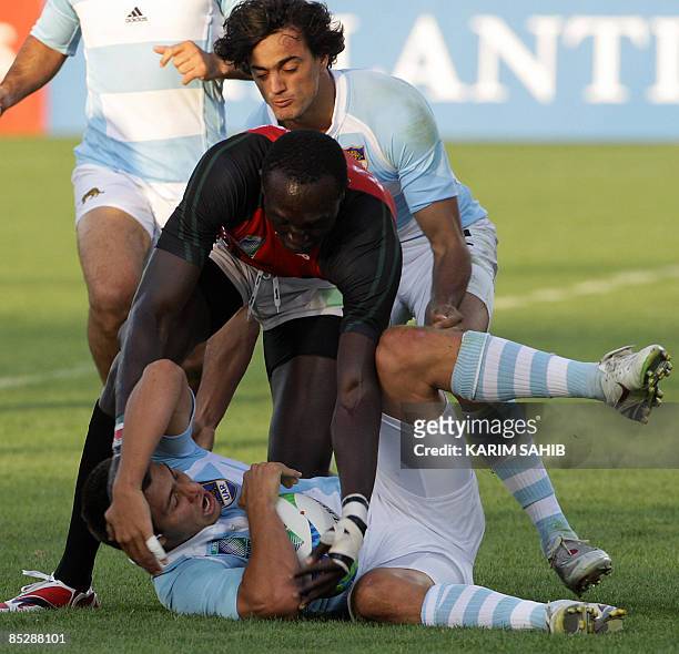 Argentina's Martin Bustos Moyano and his teammate Lucas Gonzalez Amorosino fight for the ball with Kenya's Humphrey Kayange during their Rugby World...