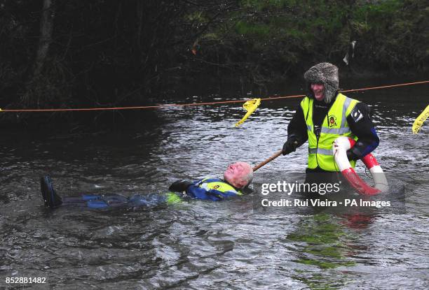 Charity competitor Gerald Sargent is helped back to shore after he jumped 30ft off of Mapleton Bridge into the River Dove during The Mapleton boat...