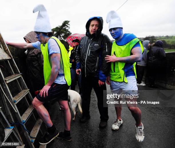 Charity competitors, dressed as Smurfs, prepare to jump 30ft off of Mapleton Bridge into the River Dove during The Mapleton boat race and bridge...