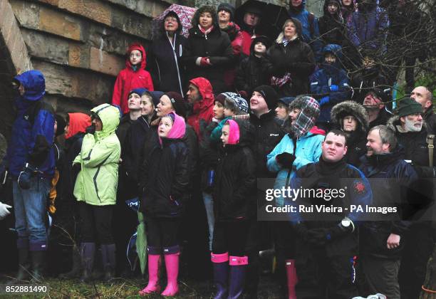 Spectators brave the weather to watch competitors jump 30ft off of Mapleton Bridge into the River Dove during The Mapleton boat race and bridge jump,...