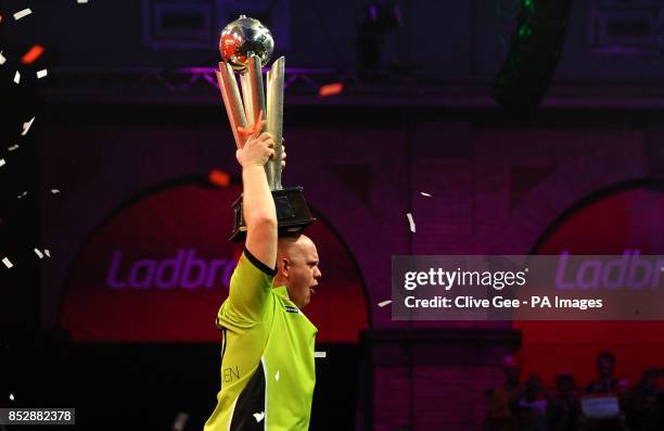 Michael Van Gerwen holds aloft the Sid Waddell trophy after winning the Final of The Ladbrokes World Darts Championship at Alexandra Palace, London.