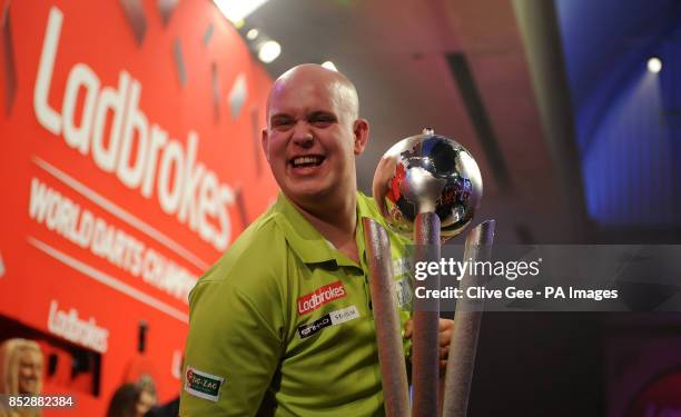 Michael Van Gerwen smiles as he holds the Sid Waddell trophy after winning the Final of The Ladbrokes World Darts Championship at Alexandra Palace,...