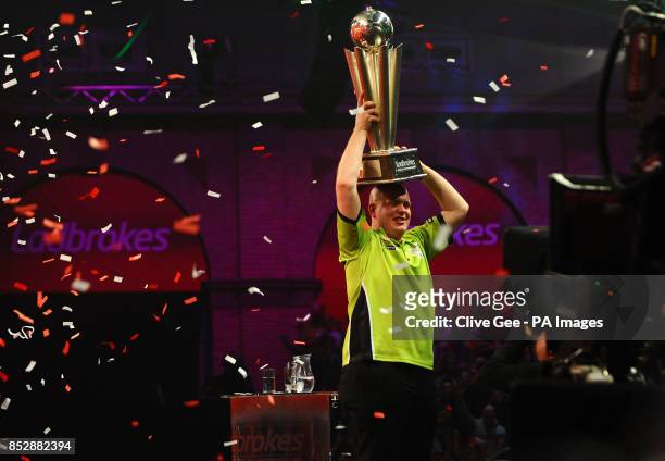 Michael Van Gerwen holds aloft the Sid Waddell trophy after winning the Final of The Ladbrokes World Darts Championship at Alexandra Palace, London.