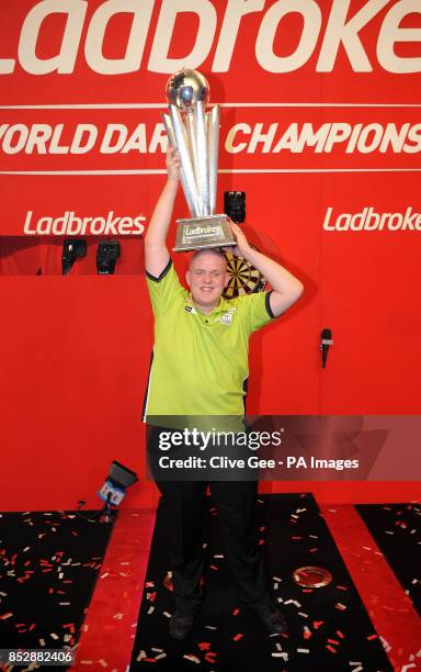 Michael Van Gerwen holds aloft the Sid Waddell trophy after winning the Final of The Ladbrokes World Darts Championship at Alexandra Palace, London.