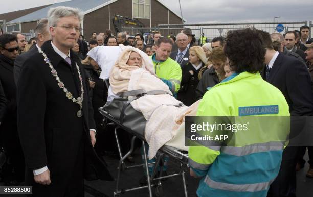 Haarlemmermeer mayor Theo Weterings walks along a survivor of the Turkish Airlines crash among family members and paramedics as they attend a...