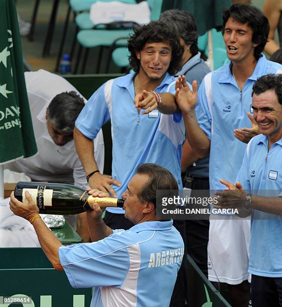 Argentina's team captain Modesto Vazquez drinks champagne as players Juan Monaco and Juan Ignacio Chela and deputy team captain Ricardo Rivera look...