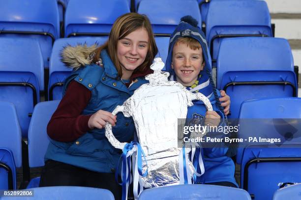 Young Everton fans holding a homemade FA cup trophy in the stands before the match