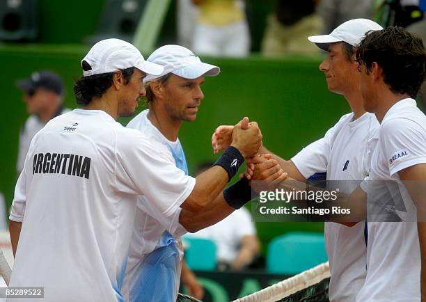 Argentina's tennis players Martin Vasallo Arguello and Lucas Arnold shake hands with Netherland's tennis players Jesse Huta Galung and Rogier Wassen...