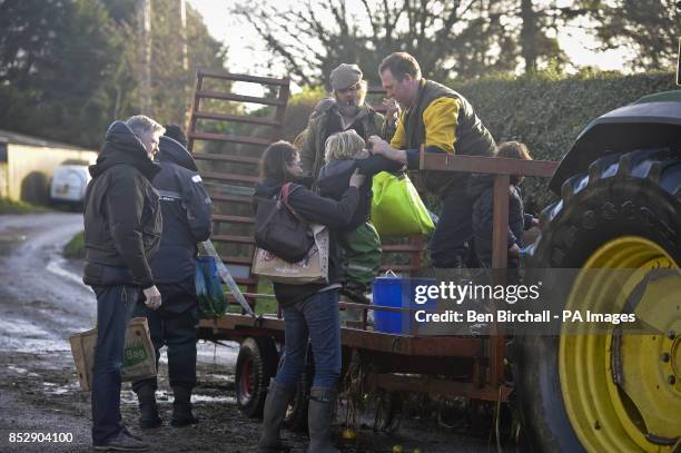 Residents near the village of Muchelney, Somerset, hitch a ride on a tractor trailer through flooded roads to reach unblocked roads after homes were...