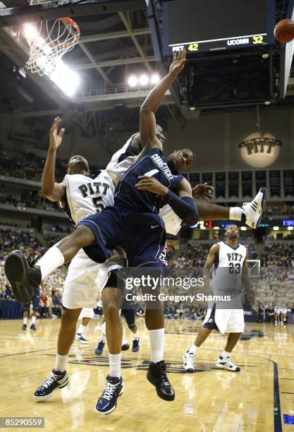 Jeff Adrien of the Connecticut Huskies gets his shot blocked by DeJuan Blair and Tyrell Biggs of the Pittsburgh Panthers on March 7, 2009 at the...