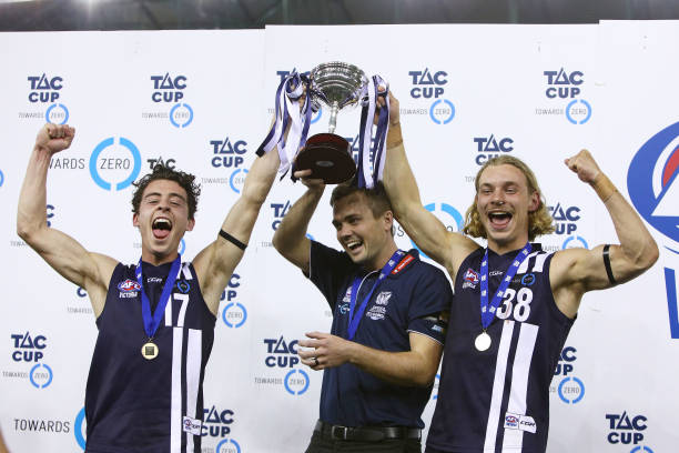 Geelong Falcons coach Daniel O'Keefe and captains James Worpel and Cooper Stephens celebrate with the trophy after winning during the TAC Cup Grand...