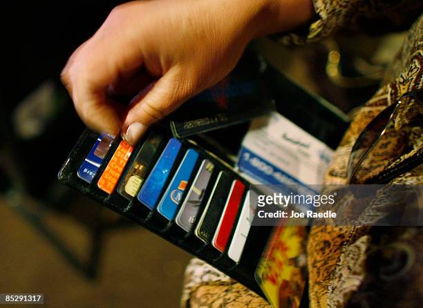 Ileana Garcia looks in her wallet for credit cards she wants to melt over a hot plate as she tries to dig herself out of credit card debt during a...