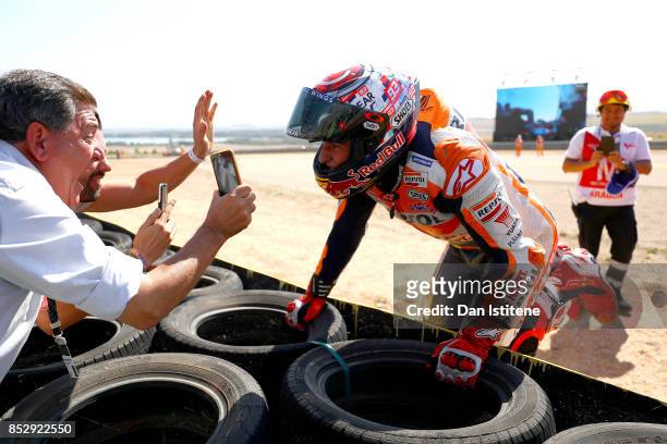 Marc Marquez of Spain and the Repsol Honda Team celebrates victory with his fans by the side of the track after the MotoGP of Aragon at Motorland...