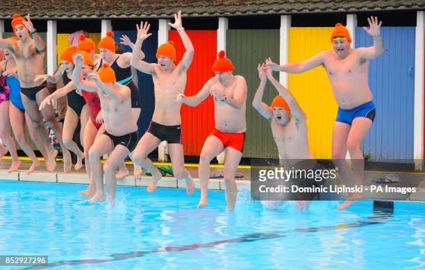 Cold weather swimmers jump in to take a swim at Tooting Bec Lido, in Tooting, south London, wearing orange bobble hats in support of homeless charity...