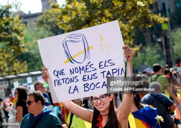 Pro-referendum demonstrator holds a placard reading "Only kisses cover our mouths" during a demonstration outside Barcelona's university in Barcelona...