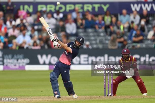 Moeen Ali of England hits out off the bowling of Ashley Nurse as wicketkeeper Shai Hope of West Indies looks on during the third Royal London One Day...