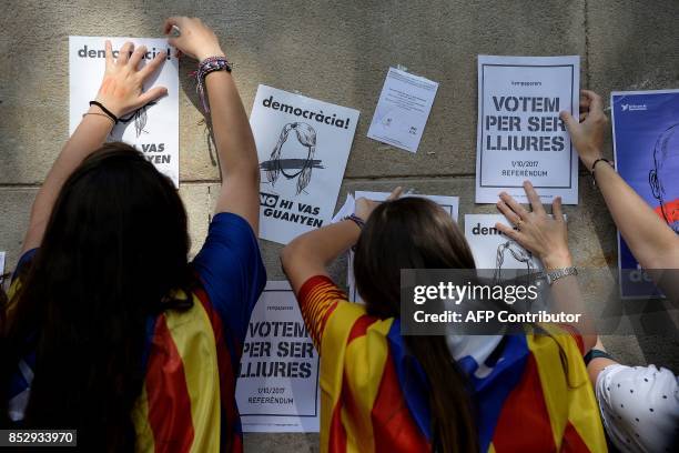 Pro-referendum demonstrators display placards on a wall during a demonstration outside Barcelona's university in Barcelona on September 24, 2017....