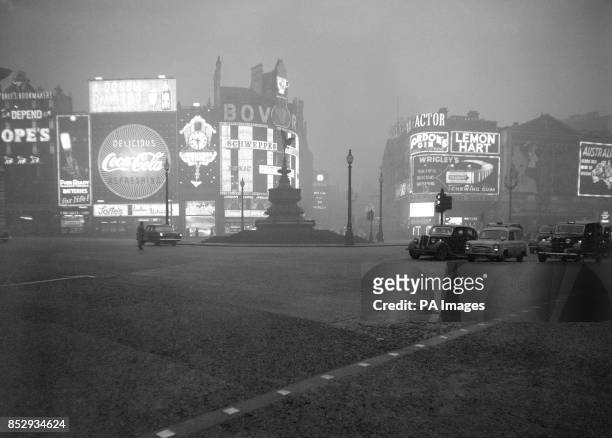 Morning looks like midnight in Piccadilly Circus at 9:30 am. As with the worst fog of the winter still shrouding London, electric signs blaze through...