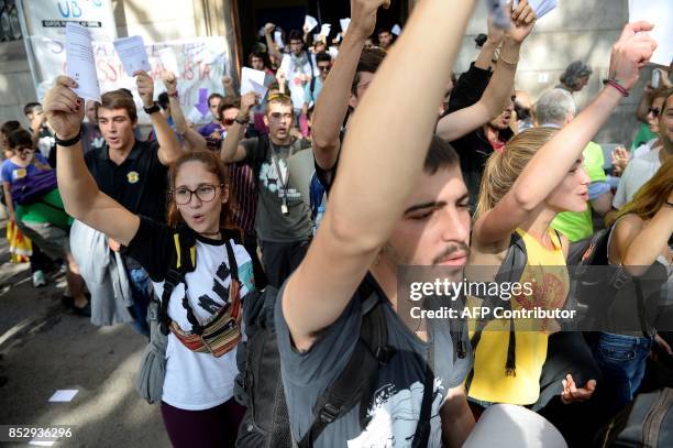 Pro-referendum demonstrators brandish their ballots during a demonstration outside Barcelona's university in Barcelona on September 24, 2017. Spain's...