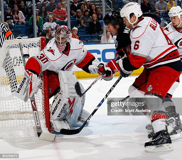 Goaltender Cam Ward of the Carolina Hurricanes makes a save against Ryan Malone of the Tampa Bay Lightning as he is defended by Tim Gleason at the...