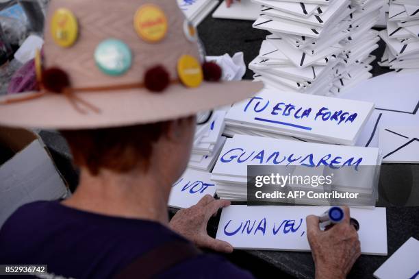 Pro-referendum demonstrator writes slogans on placards for a demonstration outside Barcelona's university in Barcelona on September 24, 2017. Spain's...