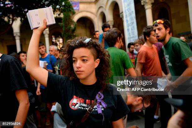Pro-referendum demonstrators brandish packs of ballots before their distibution to passer-by during a demonstration outside Barcelona's university in...