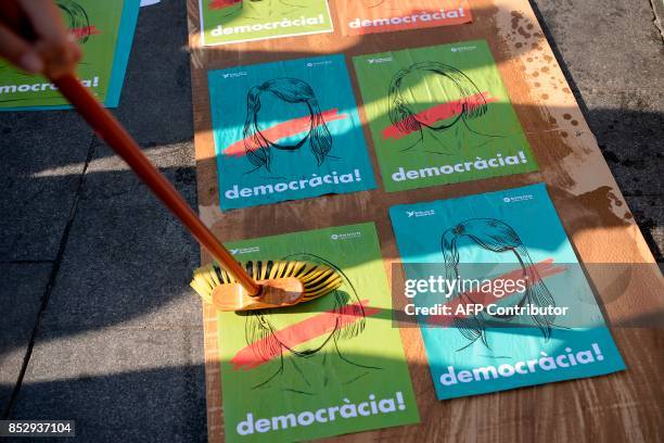 Pro-referendum demonstrator sticks posters reading "Democracy" on a board before a demonstration outside Barcelona's university in Barcelona on...
