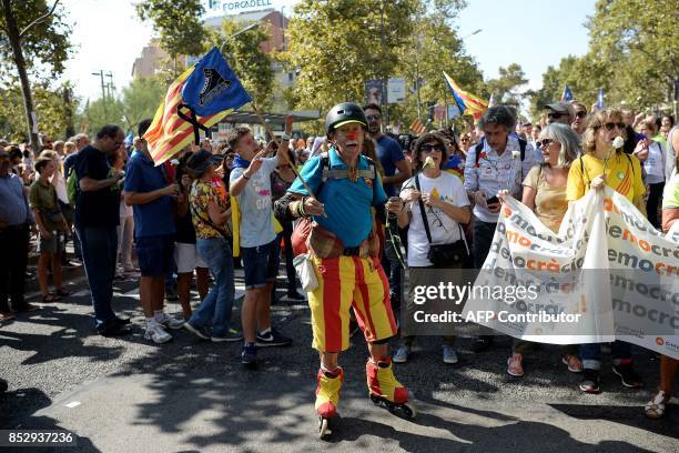 Pro-referendum demonstrator on rollers waves an Estelada during a demonstration outside Barcelona's university in Barcelona on September 24, 2017....