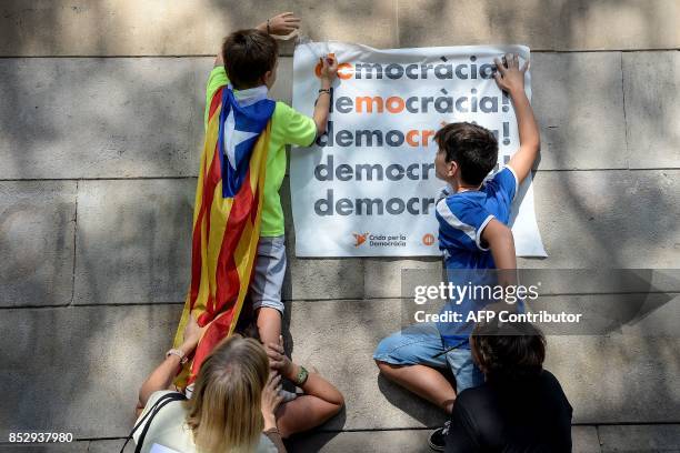 Pro-referendum demonstrators display a placard reading "Democracy" on a wall during a demonstration outside Barcelona's university in Barcelona on...