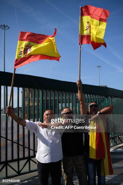 People wave Spanish flags as they gather at Barcelona's port bringing food and drinks to Spanish National Police and Guardia Civil officers, who are...