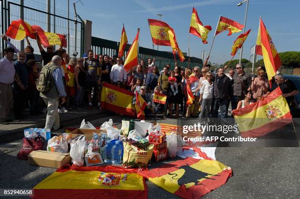 People wave Spanish flags as they gather at Barcelona's port bringing food and drinks to Spanish National Police and Guardia Civil officers, who are...