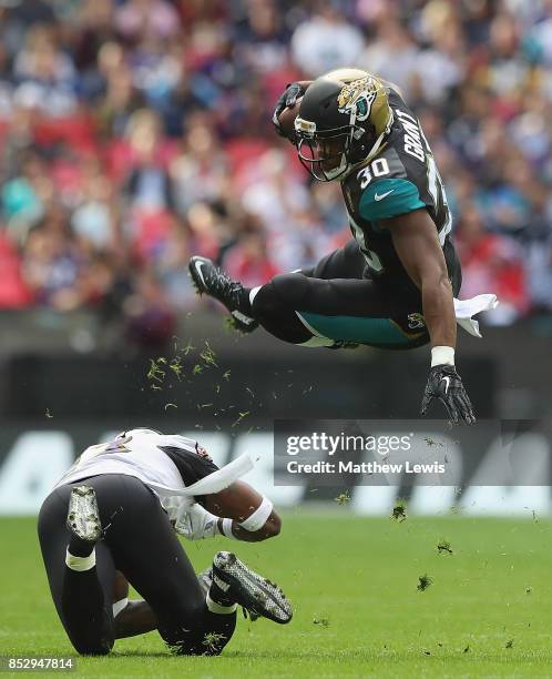 Corey Grant of the Jacksonville Jaguars is tackled Tony Jefferson of the Baltimore Ravens during the NFL International Series match between Baltimore...